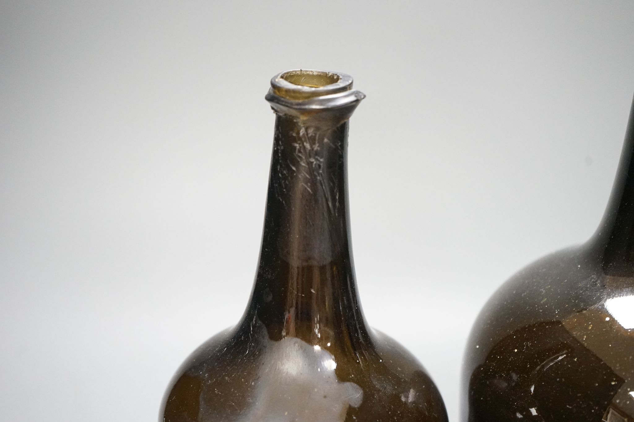 Two mid 18th century glass mallet-shape wine bottles, tallest 27cm